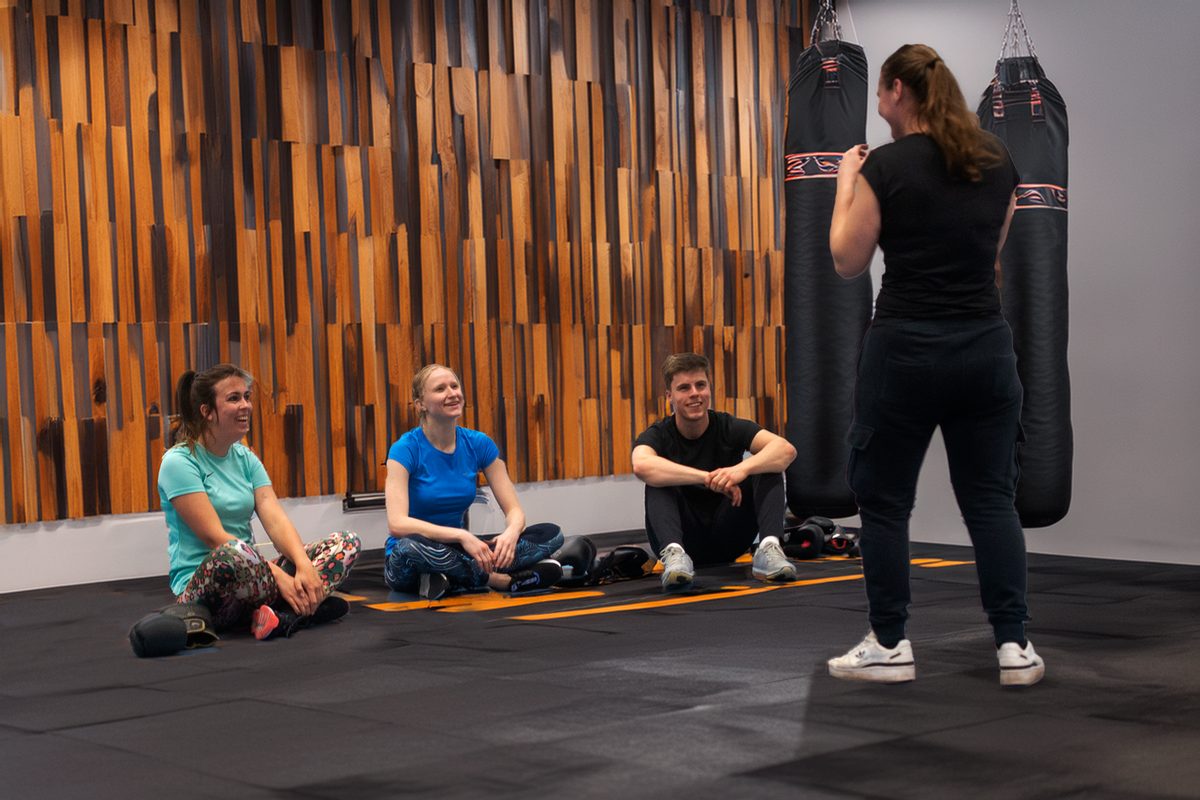Bokszaktraining: wat is het en waarom werkt het zo goed? 1 Bokszaktraining bij Sportschool Herbert in Ede: groep sporters met coach bij de bokszakken