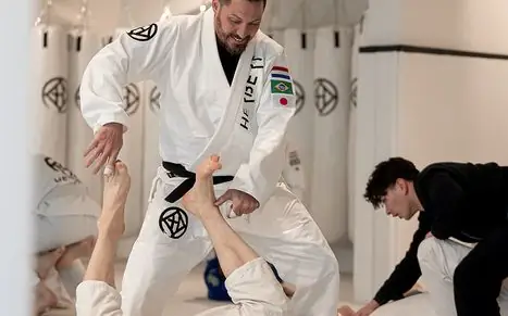 Overzicht Lessen 10 Jiu jitsu-les in Ede: trainer demonstreert een zelfverdedigingstechniek op de mat