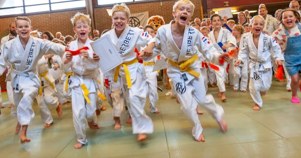 Kinderen in judopak rennen lachend over de mat tijdens Kids Judo bij Sportschool Herbert in Ede
