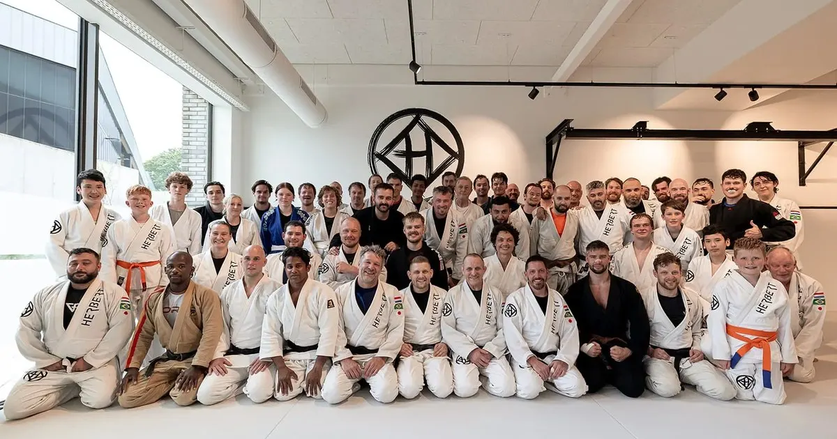 Groepsfoto van volwassen BJJ- en judosporters in de zaal van Sportschool Herbert in Ede