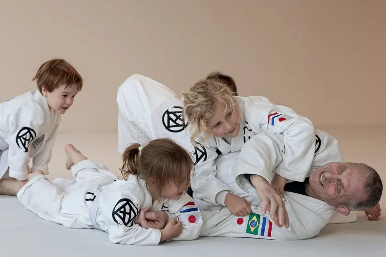 Tuimel Judo in de nieuwe judozaal van Sportschool Herbert in Ede: kleuters stoeien lachend met de docent op de witte mat